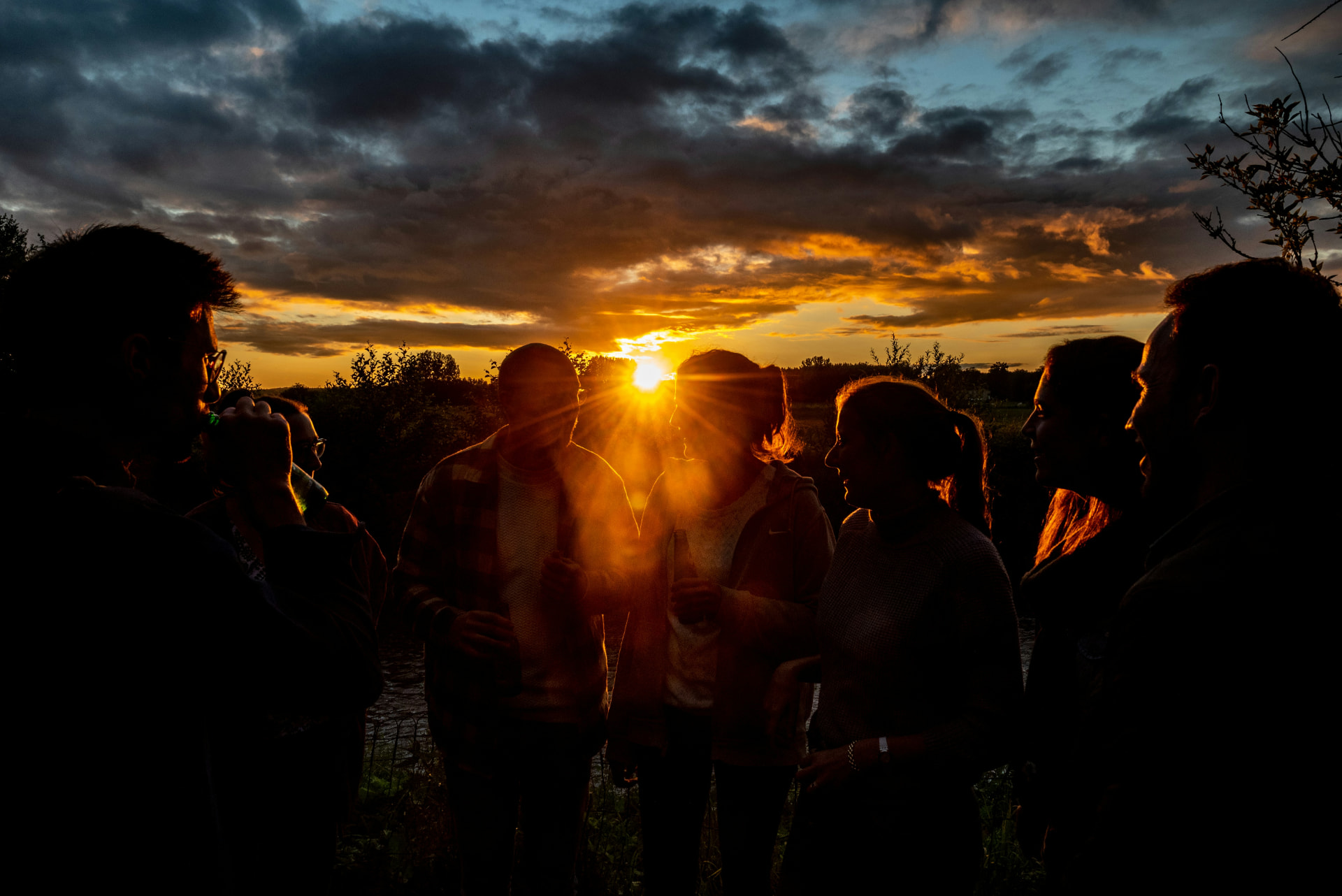 Friends talking in silhouette against a golden sunset